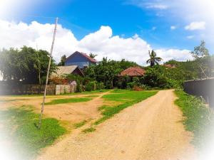 un chemin de terre devant une maison dans l'établissement Lazy Inn Kuta Lombok, à Kuta Lombok