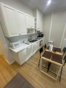 a kitchen with white cabinets and a table with chairs at Central Toronto Economical Stay-Stress Free Checkin in Toronto