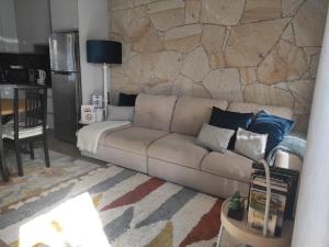 a living room with a couch and a stone wall at Casa do Fontanario em Viana do Castelo in Viana do Castelo