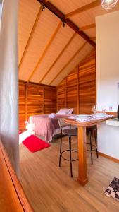 a bedroom with a bed and a table in a room at Chalés Mirante das Montanhas 