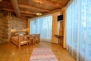 a room with a table and a bed and windows at Greete Motel in Soontaga