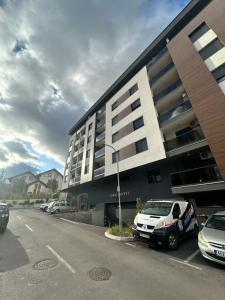 a parking lot with cars parked in front of a building at Stan na dan Banja Luka DM in Ivišovo Greblje