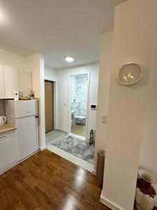a kitchen with white cabinets and a clock on the wall at Stan na dan Banja Luka DM in Ivišovo Greblje +13 photos