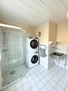ハーシュタにあるIdyllisk feriehus på vakre Bjarkøyのシャワー付きのバスルームにある洗濯機 +16枚の写真