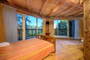 a bedroom with a bed and large windows at Greete Motel in Soontaga