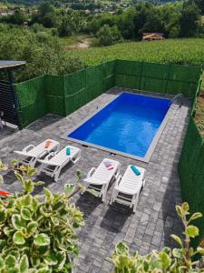 a swimming pool with two chairs and a table at Villa E&M in Srebrenik