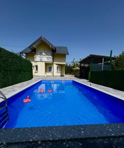 a swimming pool in front of a house at Villa E&M in Srebrenik