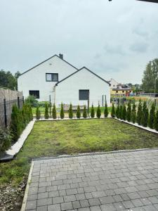 a yard with trees and a house in the background at Chill&Love Apartament 