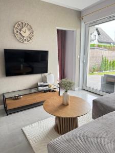 a living room with a tv and a coffee table at Chill&Love Apartament 
