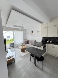 a kitchen and living room with a table and a couch at Chill&Love Apartament 