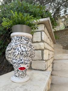 a black and white vase with a plant in it at Villa Annunziata Suite in Aragona
