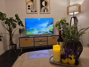 a living room with a tv and a table at Entire 3-Bed Home, 5 mins to City Centre, Sleeps 6, 2 Free Parking in Colchester