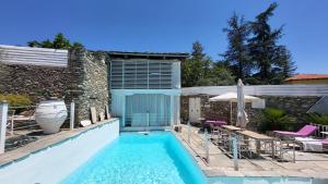 a swimming pool next to a house with a patio at Alex's Guesthouse with a pool in Dhomátia