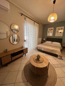 a bedroom with a bed and a table and a mirror at central studio very close to the port of Volos in Volos