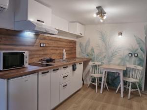 a kitchen with white cabinets and a table with chairs at Guest House Yanita in Varna City