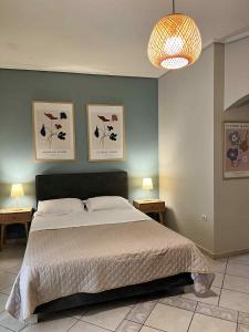 a bedroom with a bed and three pictures on the wall at central studio very close to the port of Volos in Volos