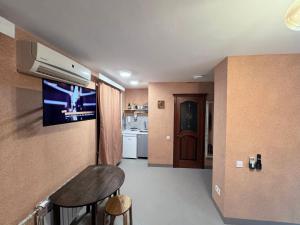 a room with a kitchen with a tv on the wall at Pilot House in Mykolaiv +16 photos