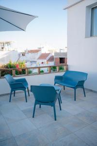 three blue chairs and a table on a balcony at Riad'a Praia in Armação de Pêra