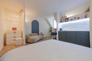 a bedroom with a white bed and a kitchen at City Mini Studio in Bratislava