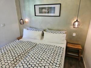 a bedroom with a bed and two pendant lights at Hey Spreewald Ferienapartments in Lübben