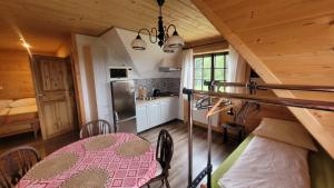 a kitchen and dining room with a table in a cabin at Chata Drapula - Gospodarstwo Agroturystyczne - Apartament na wyłączność z widokiem na góry i aneksem kuchennym in Zawadka