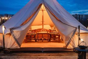 a tent with two chairs and a table in it at Pyramid Retreat in Sebeş