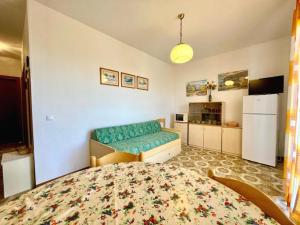 a small room with a bed and a refrigerator at Cozy apartment with terrace in Porto Santa Margherita di Caorle