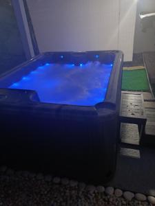a hot tub with blue water in a room at Le Cocon de l'Oranger in Le Moule