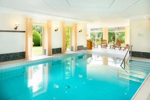 an indoor swimming pool with blue water in a house at Bio-Hotel Melter in Bad Laer