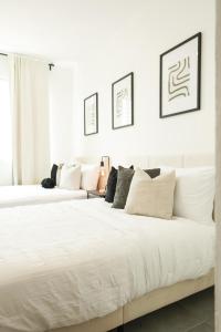 two beds in a bedroom with white walls at Modern 2BR Apt in San Juan City, Concert Stays in San Juan