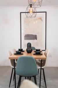 a dining room table with chairs and a painting at Modern 2BR Apt in San Juan City, Concert Stays in San Juan
