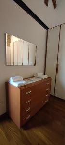 a bedroom with a dresser with a large mirror at Urban 34 - station & centre in Treviso