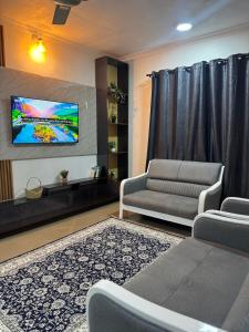 a living room with a couch and a flat screen tv at Cozy Stay Near Zanzibar Airport in Zanzibar City