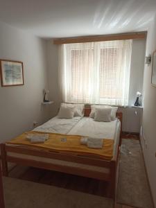 a bed in a room with a large window at Apartment RENA - private parking in Sarajevo +12 photos