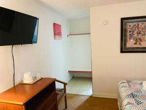 a living room with a tv and a table with a bed at Regent Motel in Albany