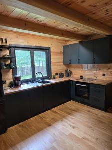 Górecko KościelneGórecko Kościelne- Domek w Lesie的一间厨房,配有黑色橱柜和大窗户