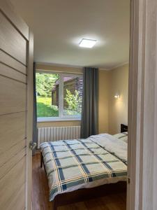 Un dormitorio pequeño con una cama y una ventana. en Vista Krasiya, en Vyshka