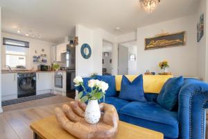 ブリクサムにあるCaptains Rest - 2 bedroom apartment in the heart of Brixhamの青いソファとテーブルのあるリビングルーム