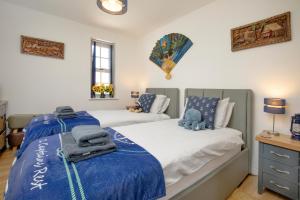 ブリクサムにあるCaptains Rest - 2 bedroom apartment in the heart of Brixhamのベッドルーム1室(青と白のシーツが備わるベッド2台付)