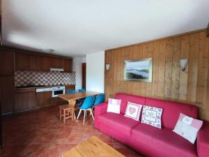 a living room with a red couch and a kitchen at Résidence Les Airelles - appartement plein sud, parking couvert - 50m des pistes MAE-8394 in Montgenèvre
