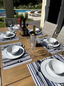 マントンにあるVilla-Monti 5 Star Superhost, Luxury Villa with pool, sleeps 7の木製テーブル(白皿、ワイングラス付) +27枚の写真