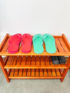 three pairs of flip flops sitting on a wooden bench at 202MSNK Luxe Studio w Balcony & Kitchen in Can Tho +16 photos