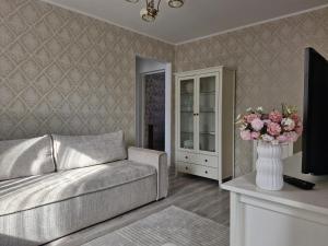 a living room with a couch and a vase of flowers at Homerent in Sfântu-Gheorghe