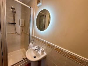 a bathroom with a sink and a mirror and a shower at Seagulls Rest - Sheringham in Sheringham