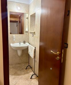 a bathroom with a sink and a mirror and a door at La Civetta in Palagianello