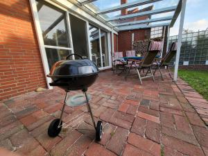 a barbecue grill sitting on a brick patio at Ferienhaus Neo in Schillig am Meer in Wangerland