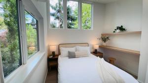 a bedroom with a bed and two windows at Brand New Designer House 15min to downtown in Seattle