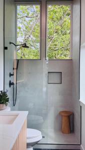 a bathroom with a shower and a toilet and two windows at Brand New Designer House 15min to downtown in Seattle