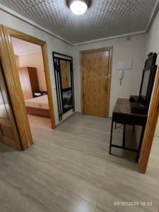 a room with a bed and a desk and a mirror at Castelar in San Vicente del Raspeig