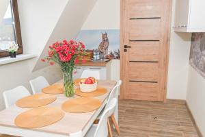 una sala da pranzo con tavolo e vaso di fiori di Sękowa Ostoja 